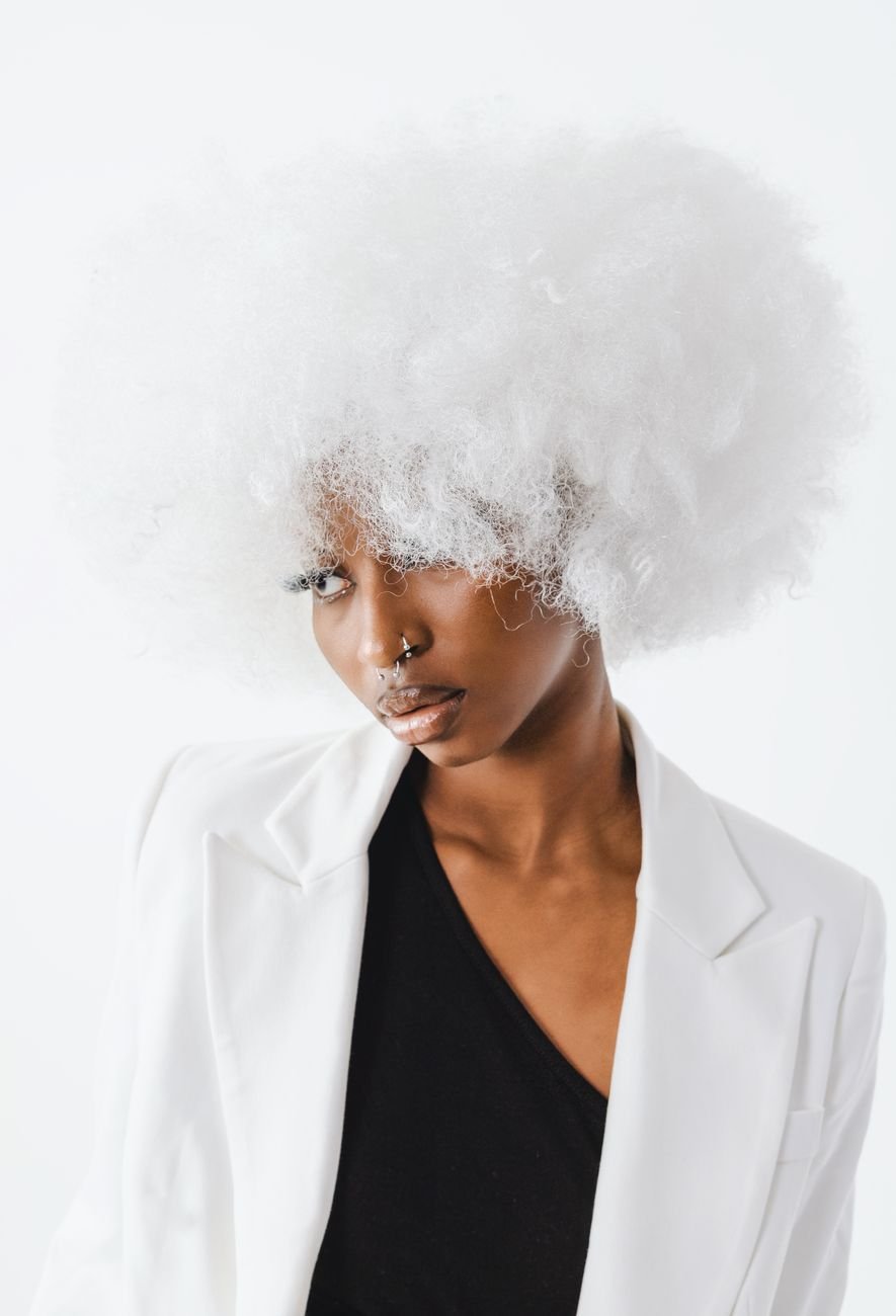 Fashionable woman with a fluffy white afro wig in an elegant studio portrait