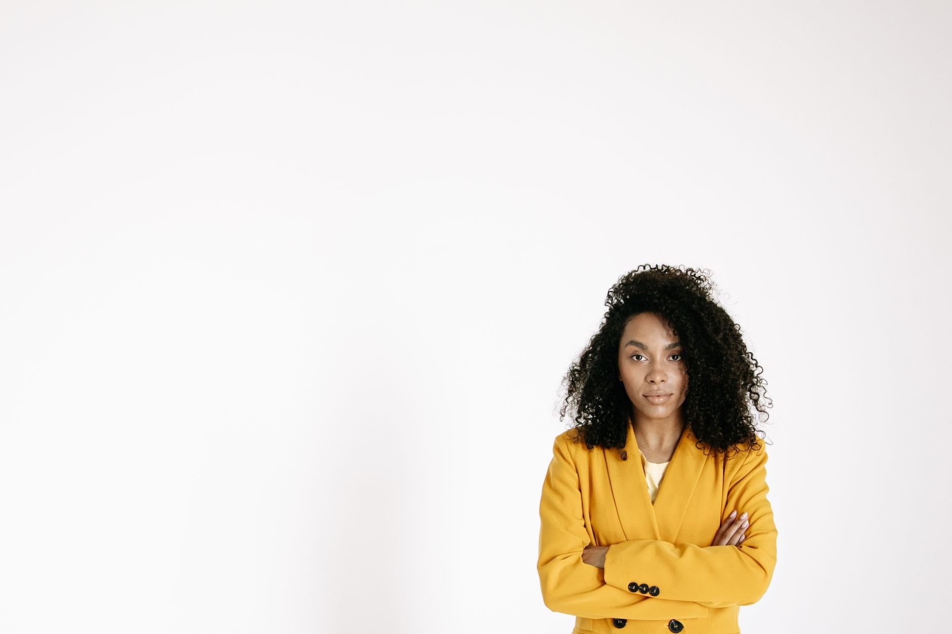 Confident woman with natural hair in a yellow blazer — the Velour Wigs spirit